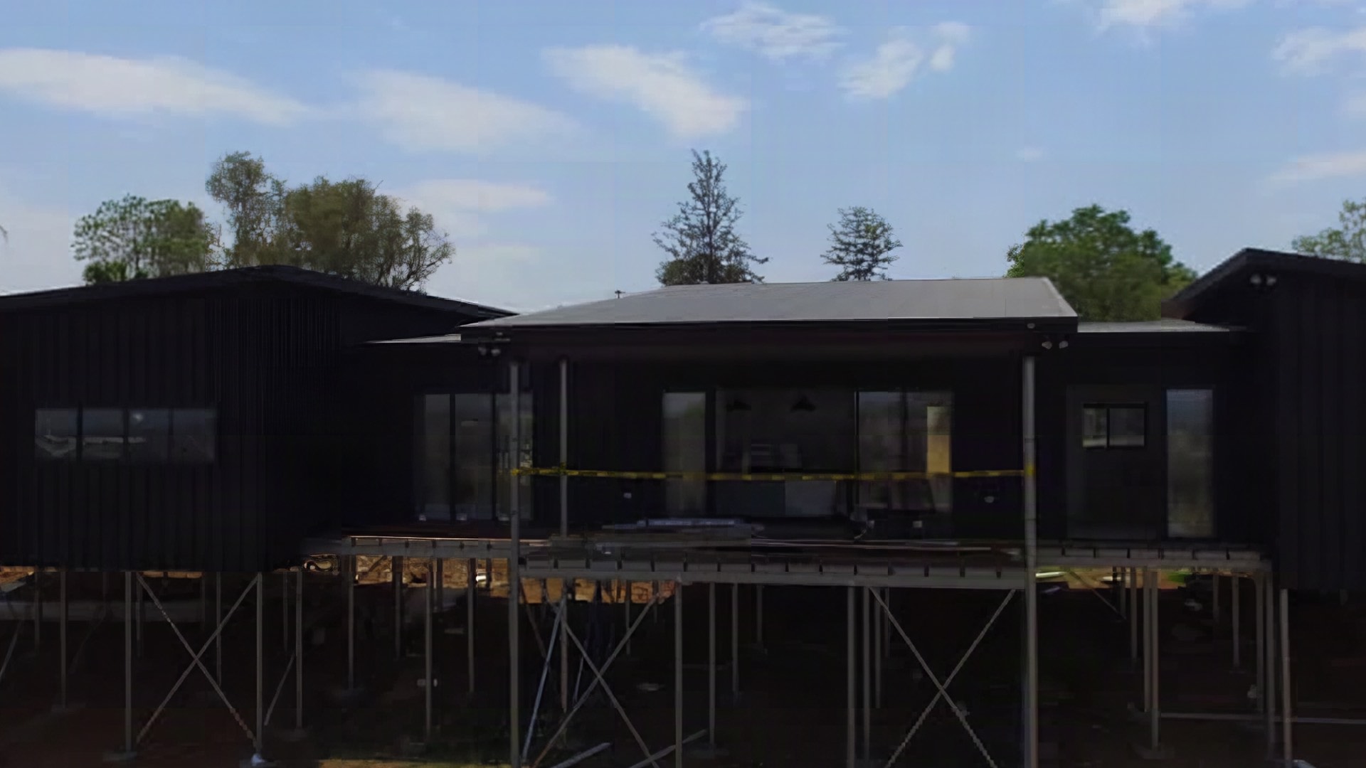 A dark steel roof on a building set on red-brown ground