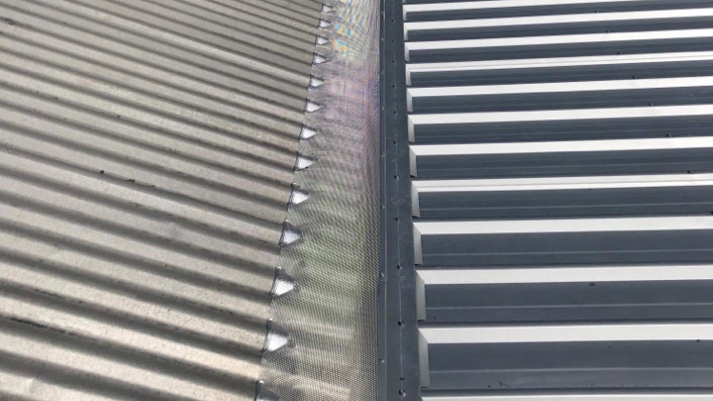 Close view of corrugated steel roof sheeting running up to the ridge