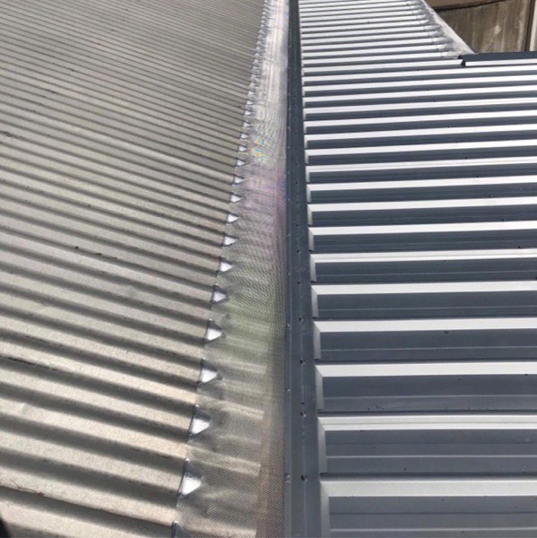 Close view of corrugated steel sheeting running up to the ridge