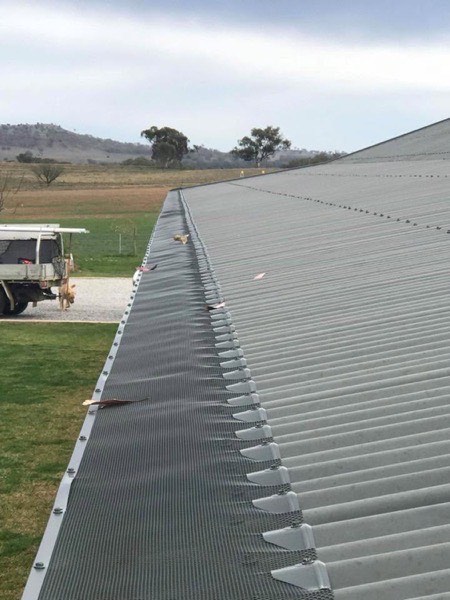 A large steel shed roof with a truck parked beside it