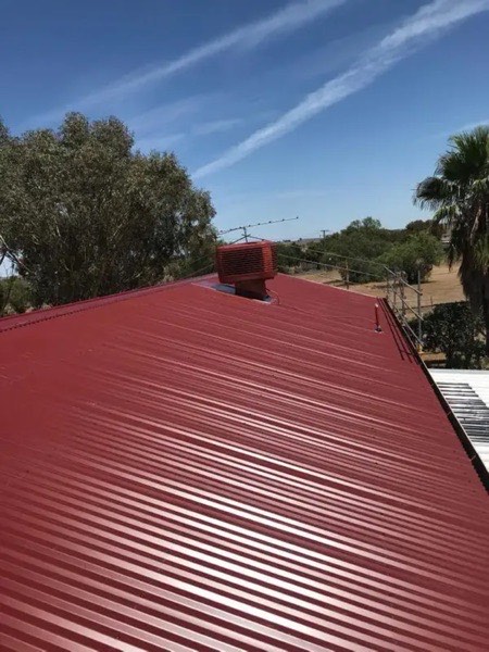 A red roof and a grey steel roof on neighbouring buildings