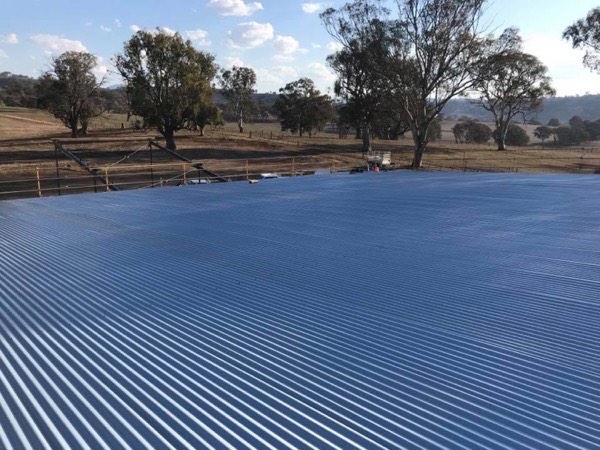 A wide blue Colorbond roof looking out over dry paddocks