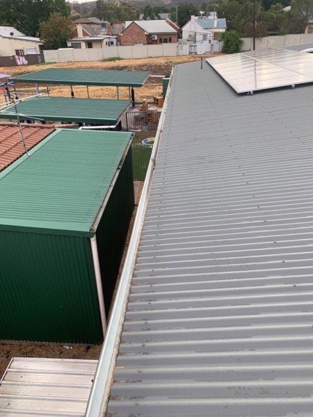 A green steel shed roof seen from the ridge