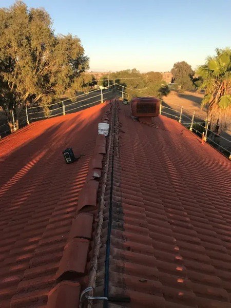 A red steel roof with a roof vent, seen from above